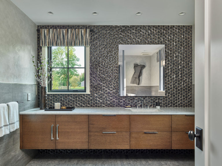 Contemporary bathroom with floating wood vanity, white marble countertop and black circle tile backsplash