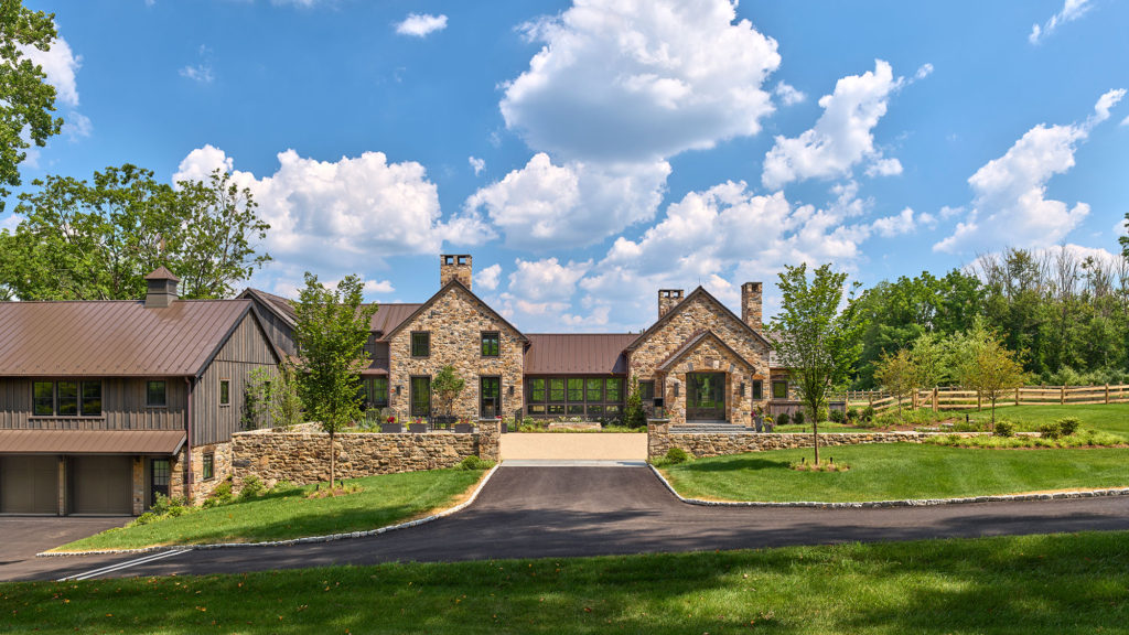 Contemporary farm house entry court with stone and board and batten siding exterior and metal roof