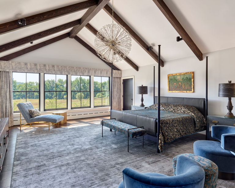 Contemporary master bedroom with vaulted ceiling, exposed beams and dark metal window frames