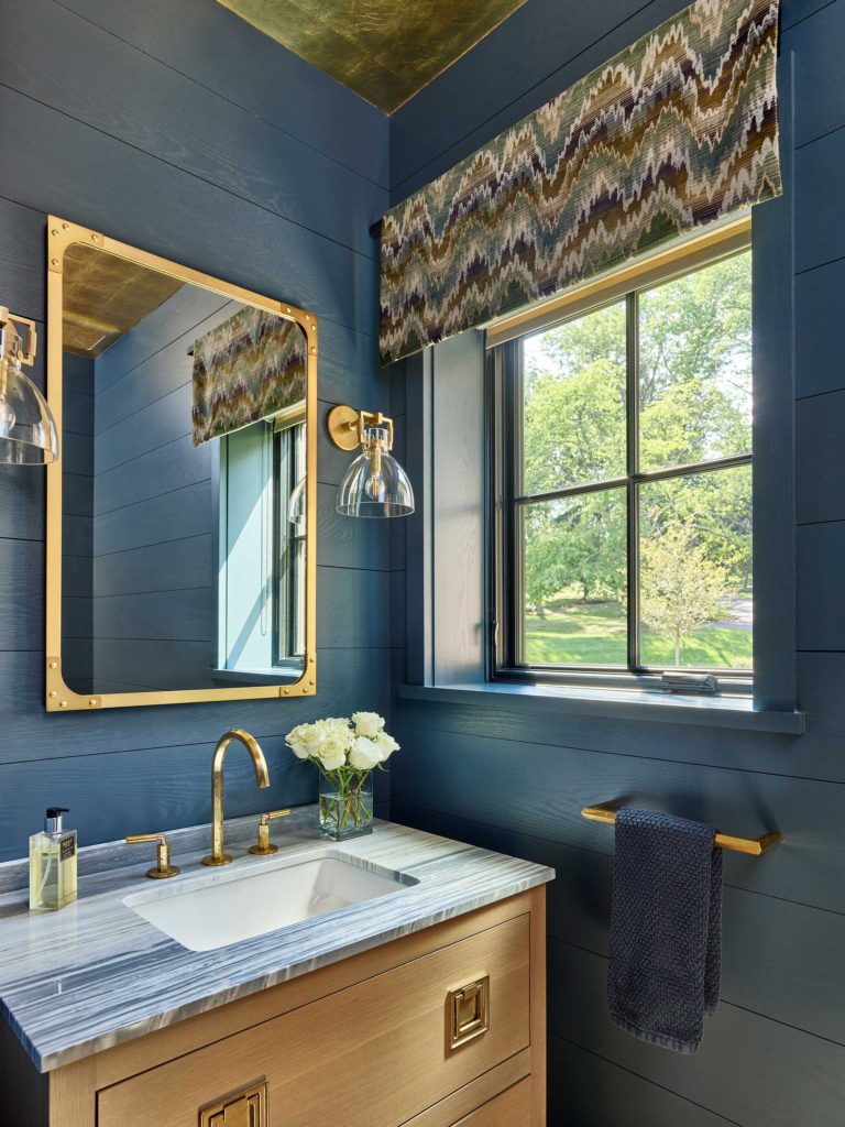 Contemporary powder room with blue walls, gold ceiling, blue and white marble vanity top and brass accents