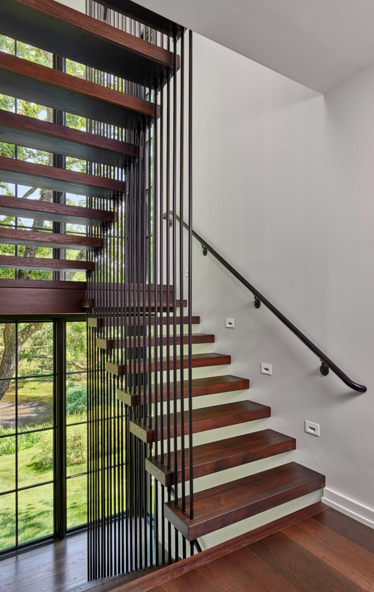 Contemporary floating stair suspended by dark metal rods with wood treads