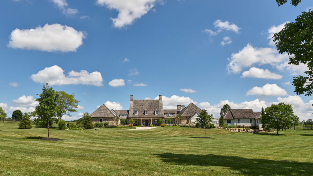 Cottage-style entry to Chestnut Fields, a Chester County farmhouse with stone and siding exterior walls and cedar shake roof.