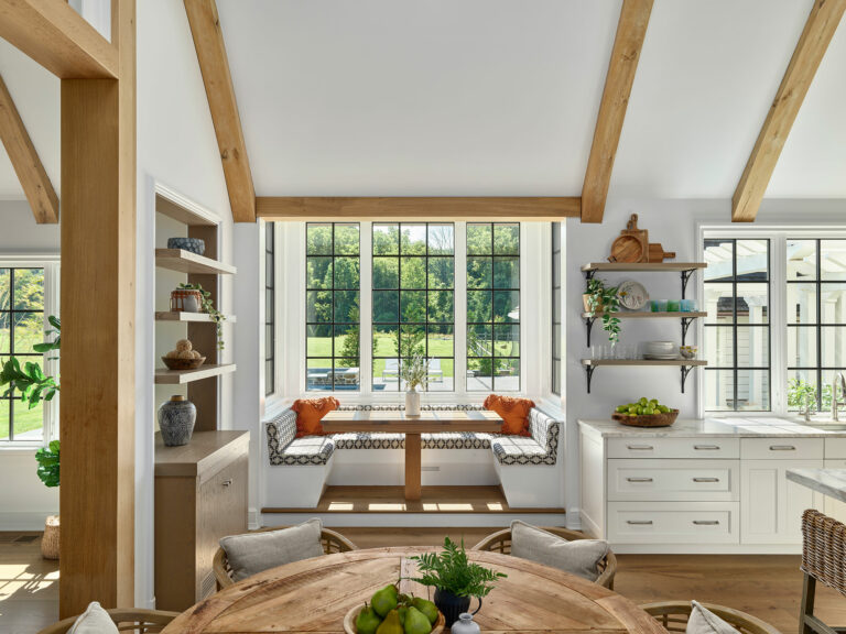 Built in breakfast nook in Chestnut Fields, a contemporary farmhouse in Chester County with white walls, black frame windows and timber frame vaulted ceiling.