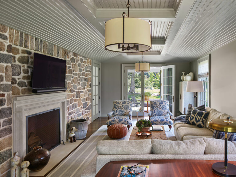 Den with fireplace, exposed brick wall and French doors to covered terrace