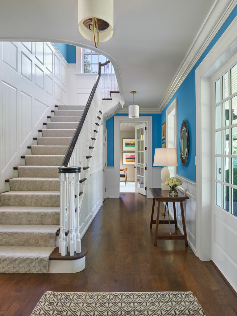 Entry and stair hall with blue walls and white millwork