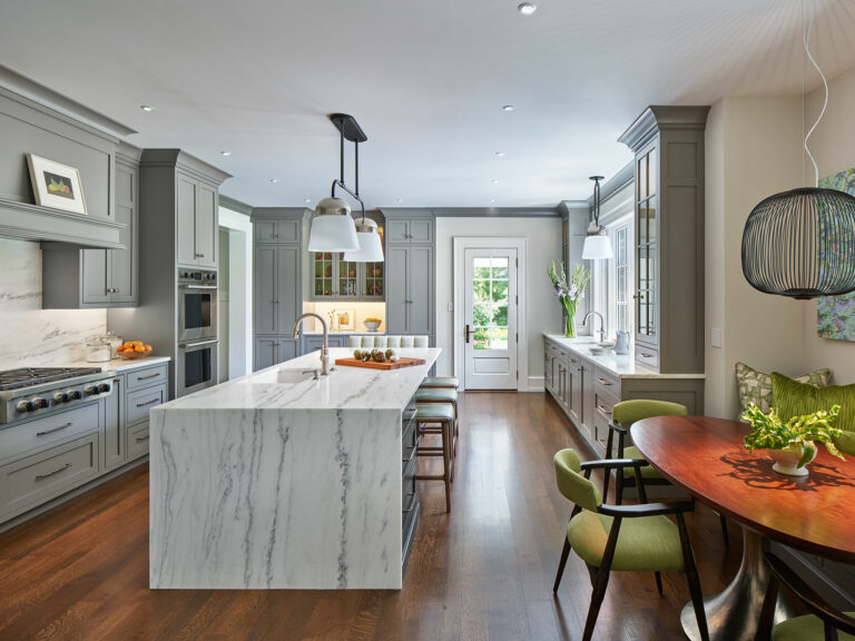 Kitchen with gray cabinets and large center island with waterfall countertop