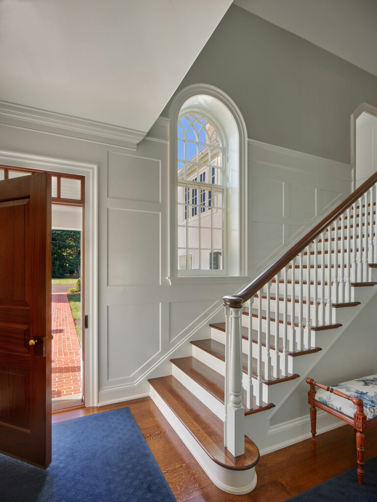 Main entry with elegant stair and arched window at Evergreen Farm