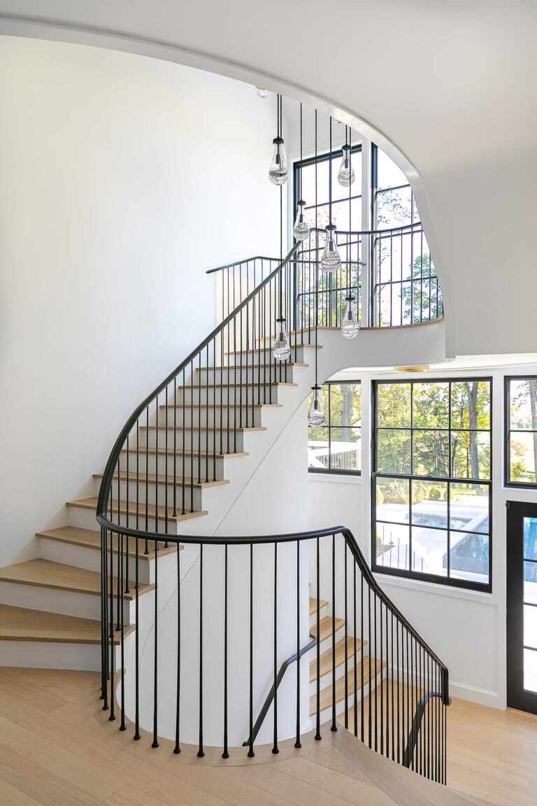 modern staircase in Fort Washington, Pennsylvania, residence with pale wood treads, white walls and black railing