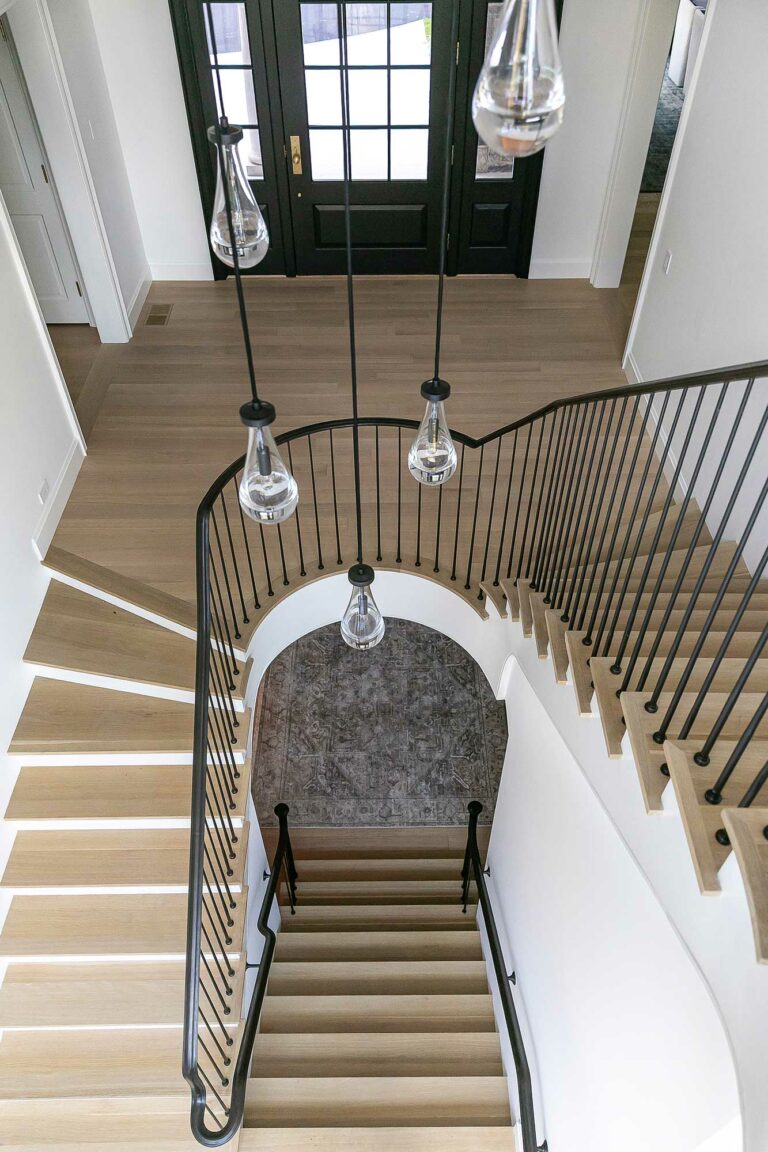 modern staircase in Fort Washington, Pennsylvania, residence with pale wood treads, white walls and black railing