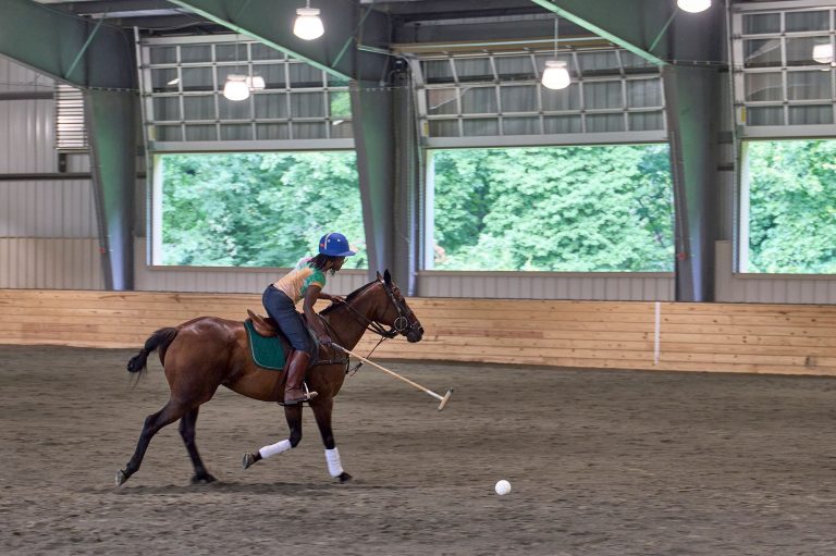 Young polo player on horse at Chamounix Stables McCausland Arena for Work to Ride program