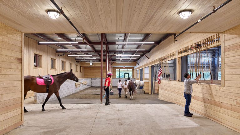 Horses and riders entering tie area at Chamounix Stables McCausland Arena for Work to Ride program